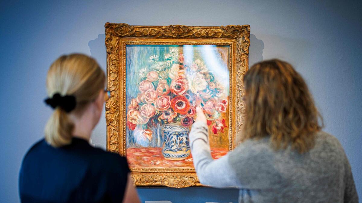 Visitors watch an artwork by French impressionist painter Auguste Renoir (1841-1919)  entitled Anemone et roses (Anemones and Roses) (about 1910) at the Fondation de l’Hermitage museum in Lausanne on Wednesday. — AFP