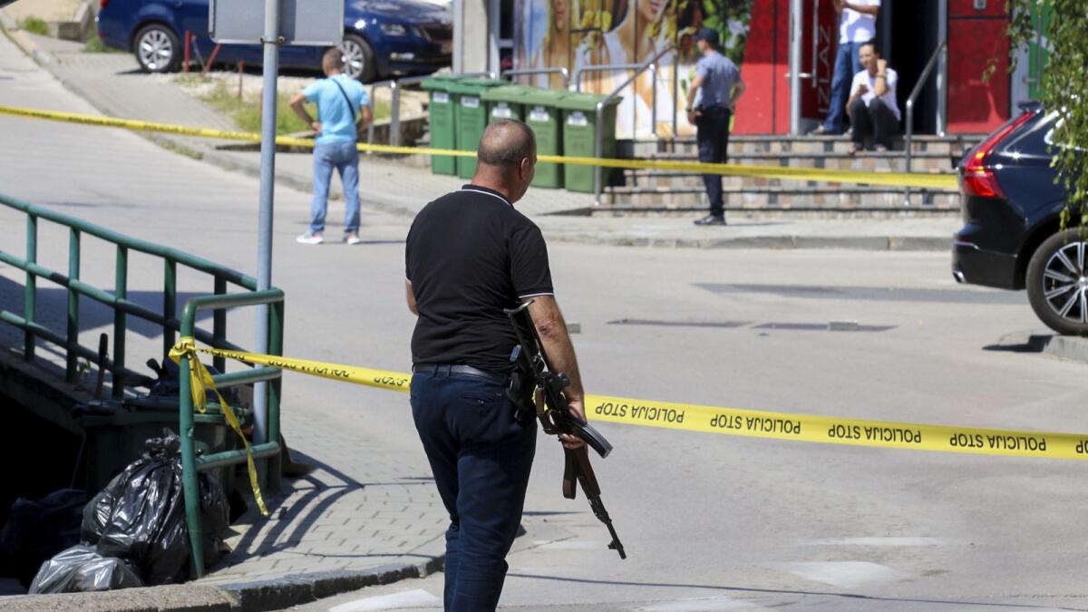 A plain-clothes police officer holds a rifle as they launch a major chase for a man who claimed to have shot and killed his wife while broadcasting it live on Instagram, in the small town of Gradacac. — AP