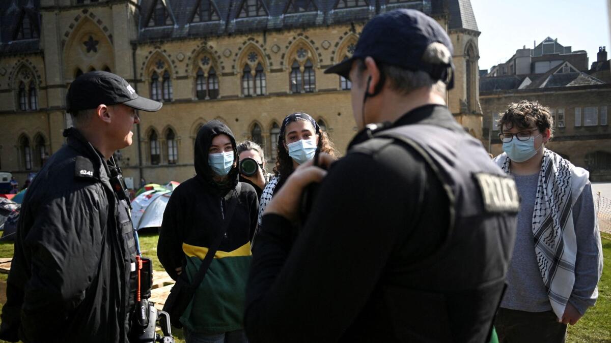 A police officer talks with protesters at Oxford University, outside Oxford University Museum of Natural History. — Photo: Reuters
