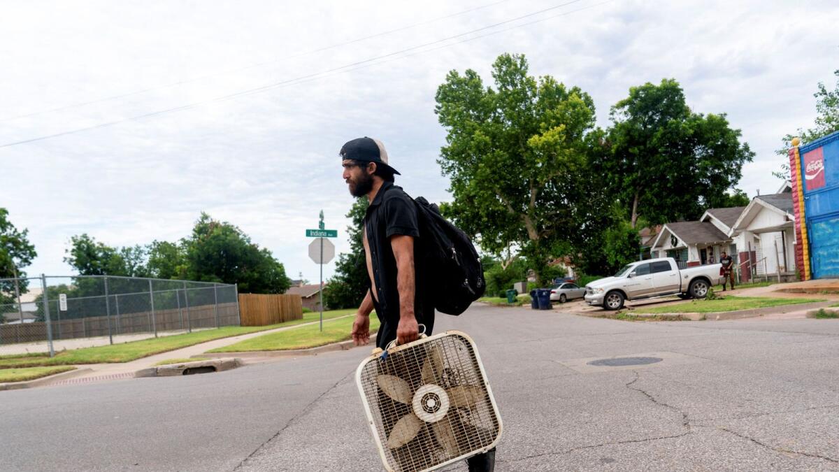 James Robinson carries a fan back to his home during an excessive heat warning in Oklahoma City, US., on June 26, 2024.  — Reuters