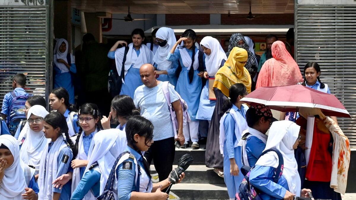 Students leaving their school compound carry umbrellas on a hot summer day in Dhaka on April 28, 2024, amid the ongoing heatwave. Photo: AFP