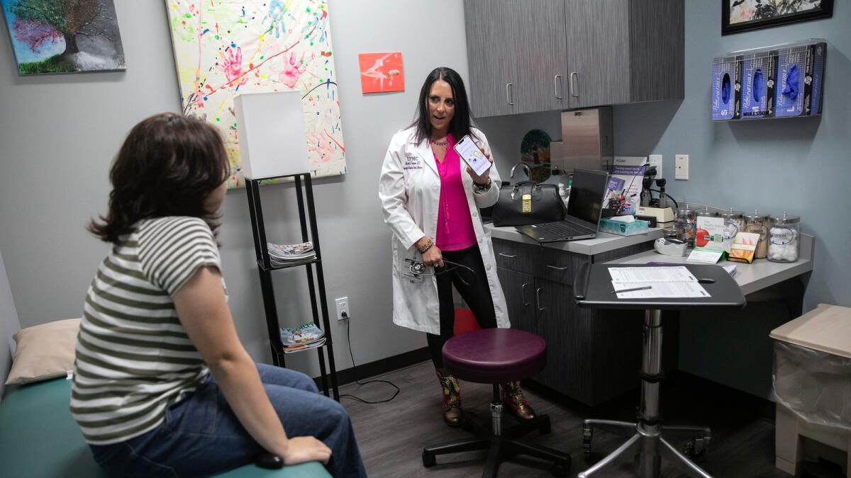 Dr Michelle Thompson, a family physician, consults with a patient in Hermitage, Pennsylvania, on June 13, 2023. Using AI software, Thompson says, has freed up two hours in her work day and has helped patients become more engaged in their care. —  Maddie McGarvey/The New York Times