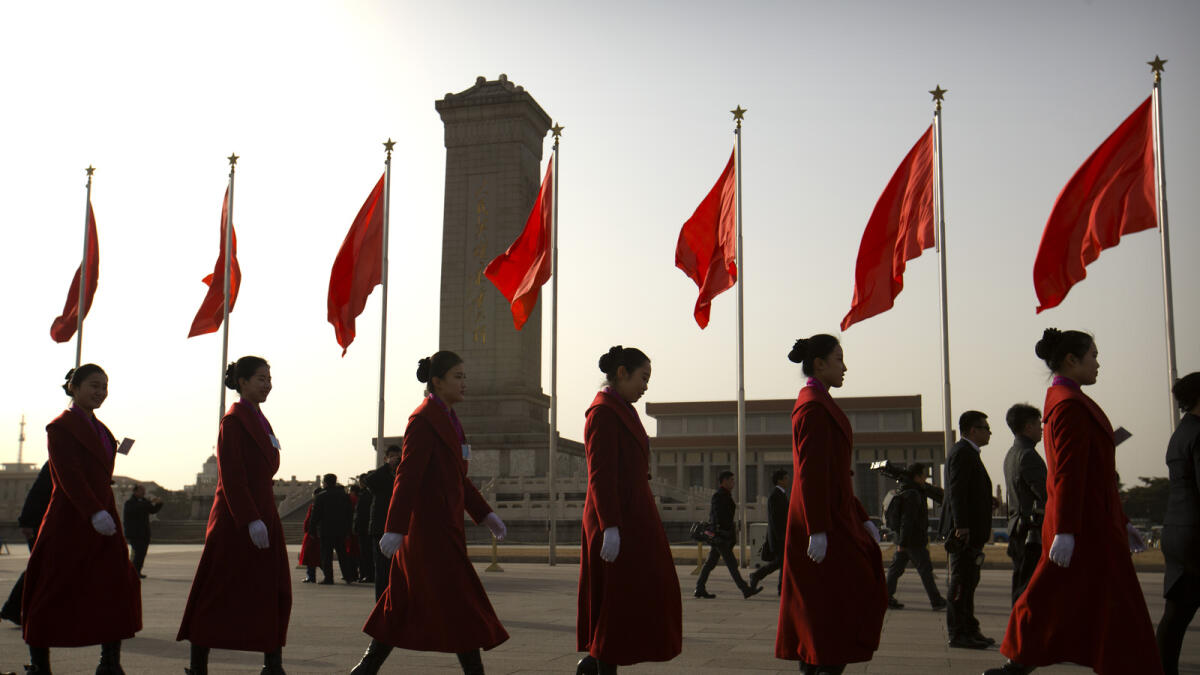 Hostesses, who facilitated the arrival of delegates by bus, walk across Tiananmen Square near the Great Hall of the People during the opening session of China's annual National People's Congress (NPC) in Beijing, Saturday, March 5, 2016. (AP Photo/Mark Schiefelbein)