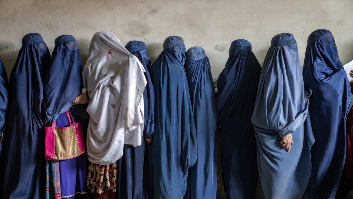 Afghan women wait to receive food rations distributed by a humanitarian aid group in Kabul. — AP file