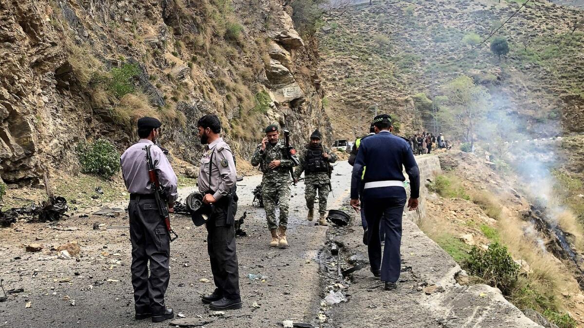 Security personnel inspect the site of a suicide attack near Besham city in the Shangla district of Khyber Pakhtunkhwa province on March 26, where five Chinese nationals working on a major dam construction site were killed. — Photo: AFP file