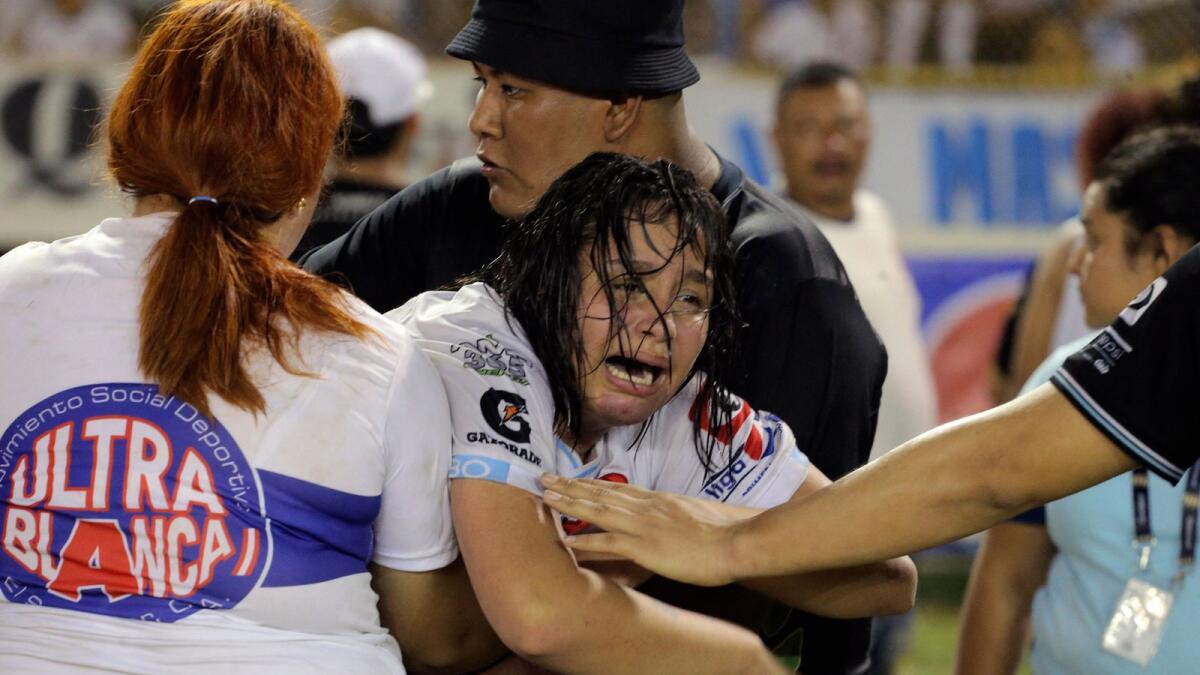 A woman is held by other as she cries following a stampede during a football match between Alianza and FAS at Cuscatlan stadium in San Salvador, on Saturday. -- AFP