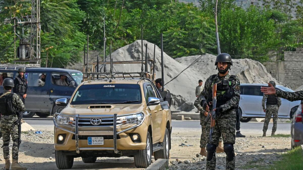 Security personnel stand guard at the site of a bomb blast in Bajaur district of Khyber-Pakhtunkhwa province. — AFP