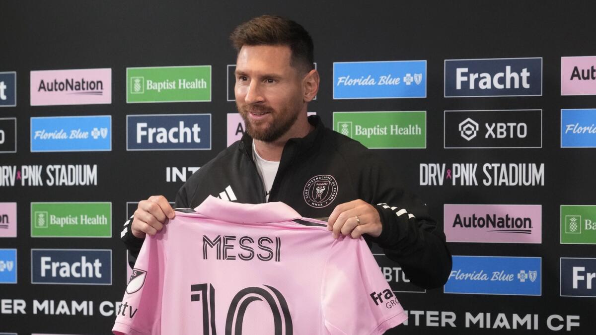 Inter Miami's Lionel Messi holds up his team jersey during a news conference on August 17, 2023, in Fort Lauderdale, Florida. (AP)