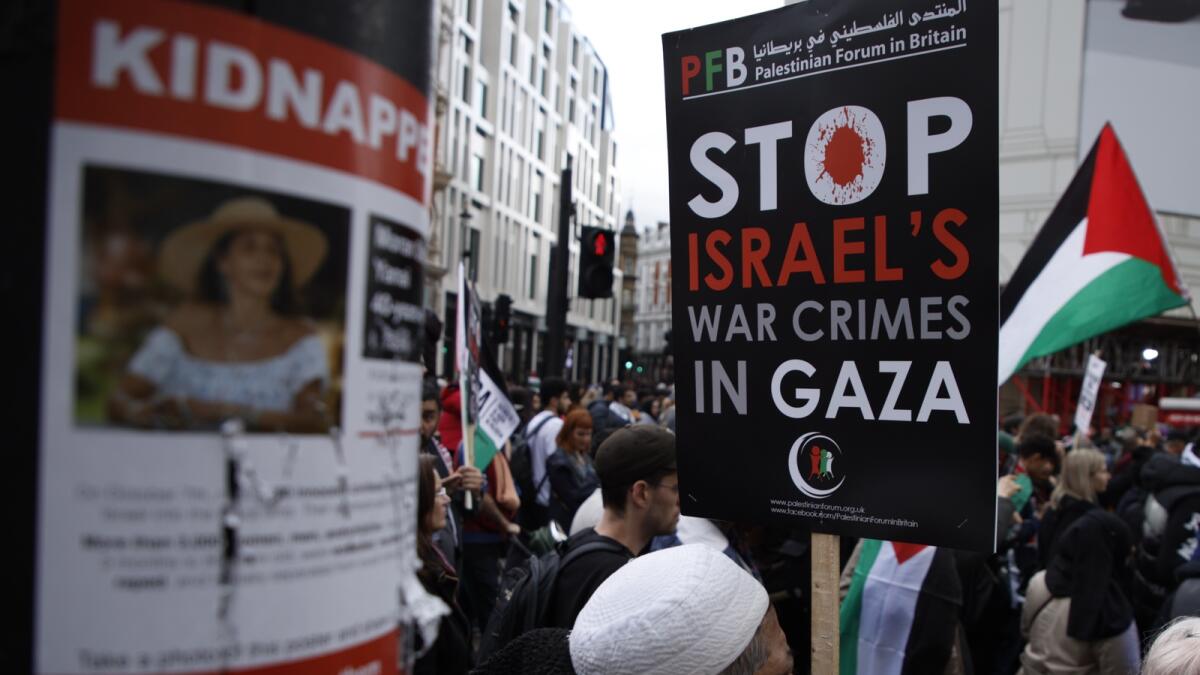 A damaged poster on a lamppost shows an image of Israeli citizens who have allegedly been kidnapped by Hamas, during a pro-Palestinian demonstration in London. — AP