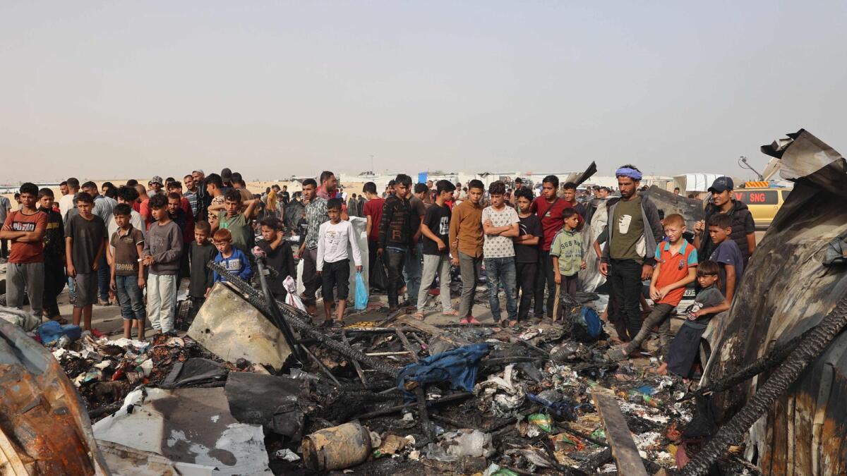 Palestinians gather at the site of an Israeli strike on a camp for internally displaced people in Rafah. — Photo: AFP