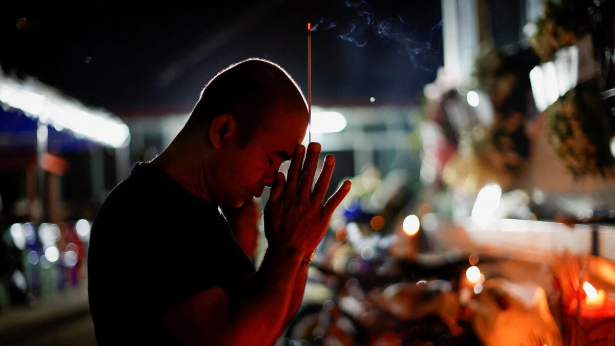 A man prays as he pays tribute, following a mass shooting at a day care centre, in the town of Uthai Sawan, in the province of Nong Bua Lam Phu, Thailand, October 9, 2022. REUTERS/Jorge Silva