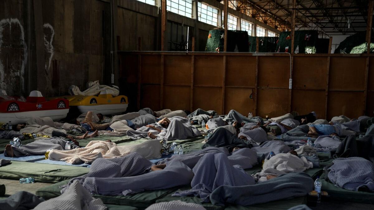 Survivors of a shipwreck sleep at a warehouse at the port in Kalamata town, about 240km southwest of Athens. — AP file