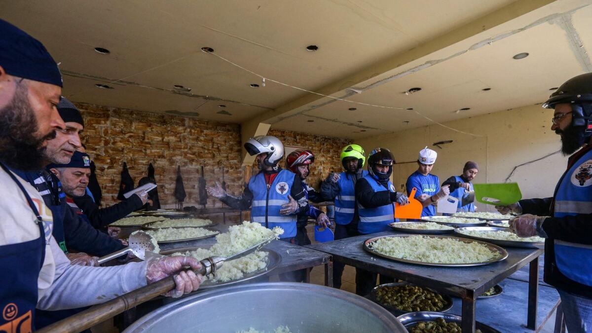 Members of motorcycle club Hope Bikers Syria help prepare distribute 'iftar' meals during the  holy fasting month of Ramadan, in Damascus. — AFP