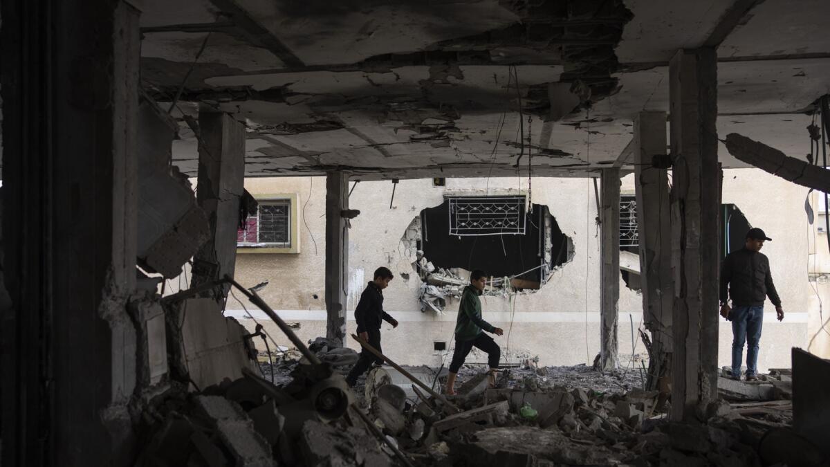 Palestinians look at the destruction after an Israeli airstrike in Rafah. — AP