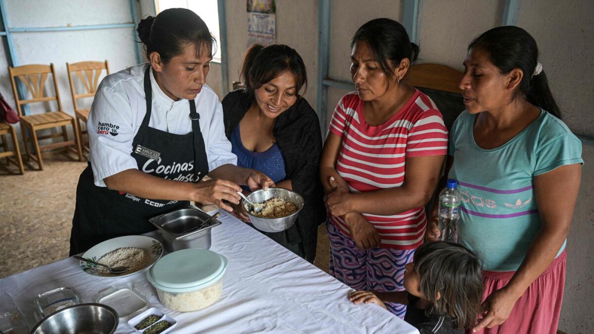 Adeli Yanos (L), president of 'Virgen del Rosario' soup kitchen, trains a group of women to prepare a dish using the peels, leaves, and stems of vegetables and fruits at the soup kitchen in Lurin, in southern Lima, on April 11, 2024. Peruvian Chef Palmiro Ocampo launched a crusade in 2018 to not waste food.  — AFP