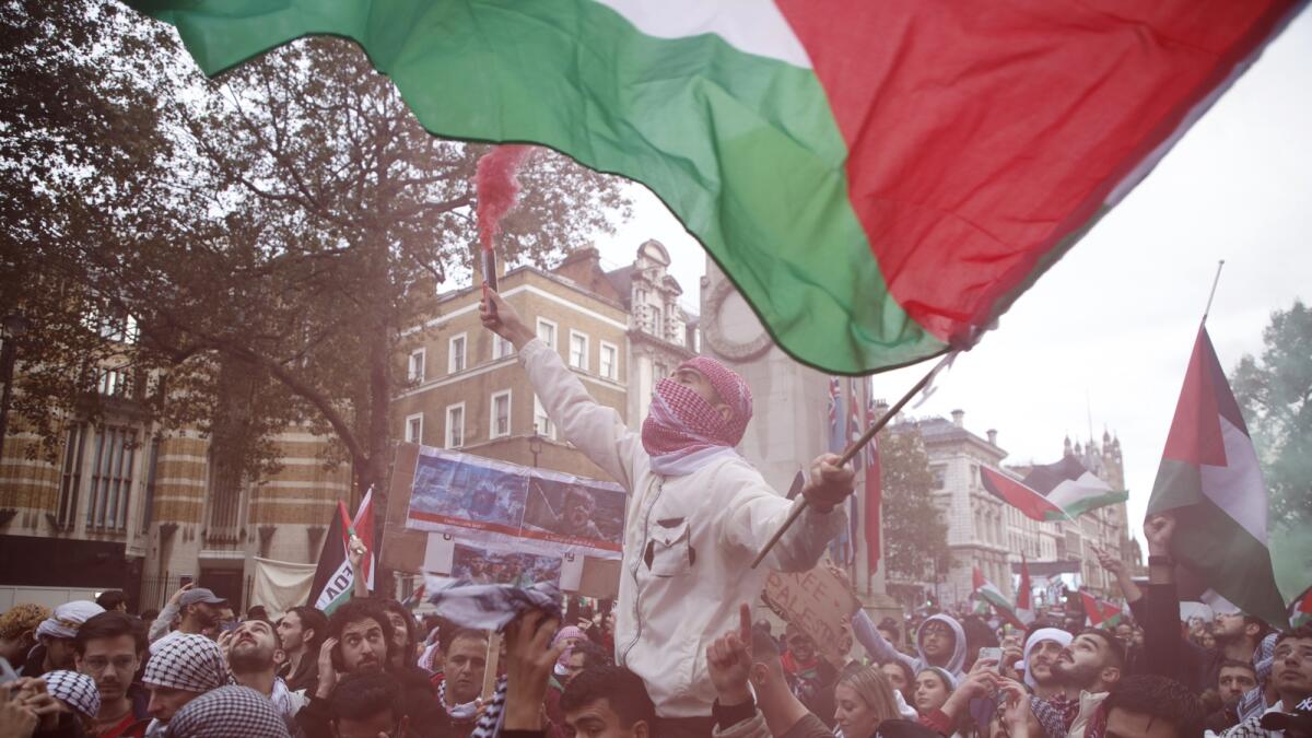 Demonstrators hold up flares, flags and placards during a pro Palestinian demonstration in London. — AP
