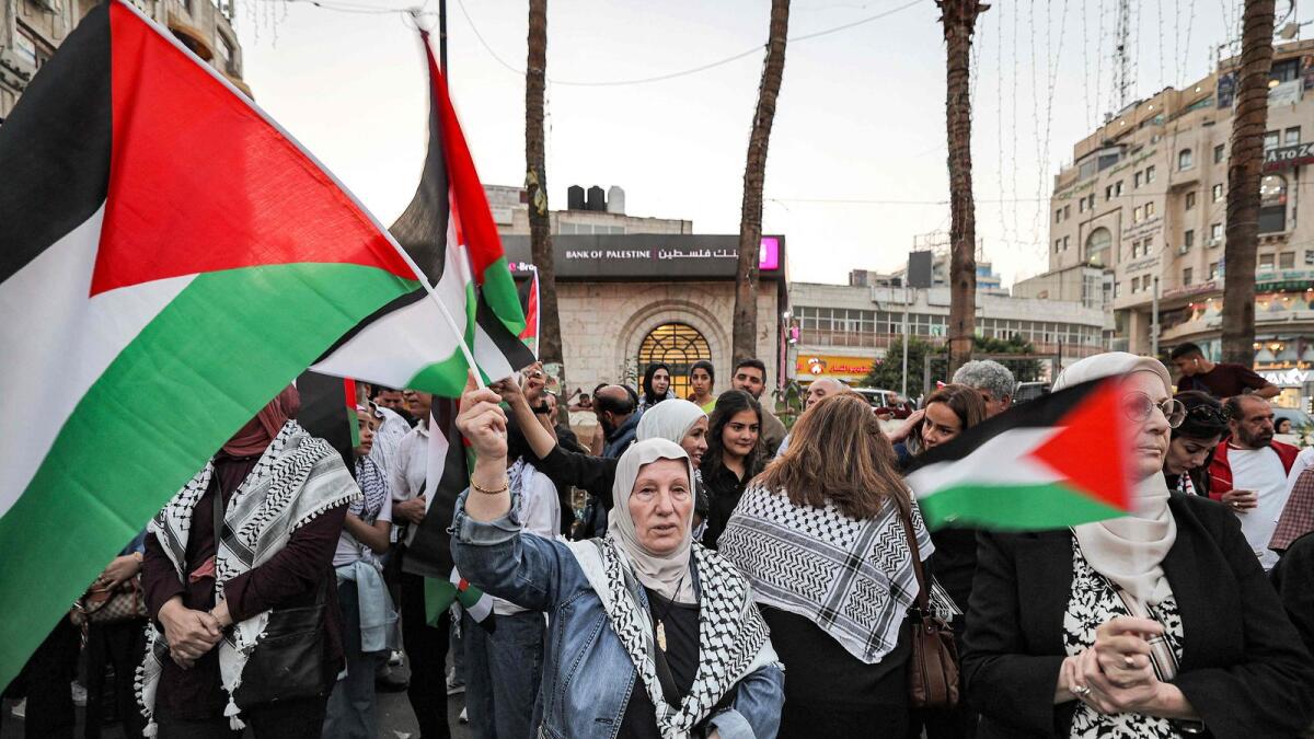 People gather with Palestinian flags for a demonstration in solidarity with people in the Gaza Strip at a square in Ramallah in the occupied West Bank. — AFP