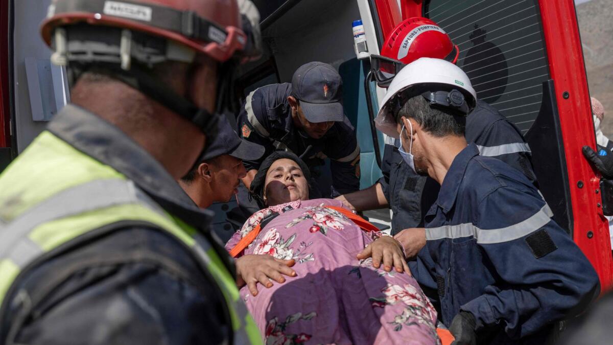 Rescue workers evacuate a survivor after they rescued her from under the rubble of an earthquake-collapsed house in Imi N'Tala village near Amizmiz on September 12, 2023.  — AFP