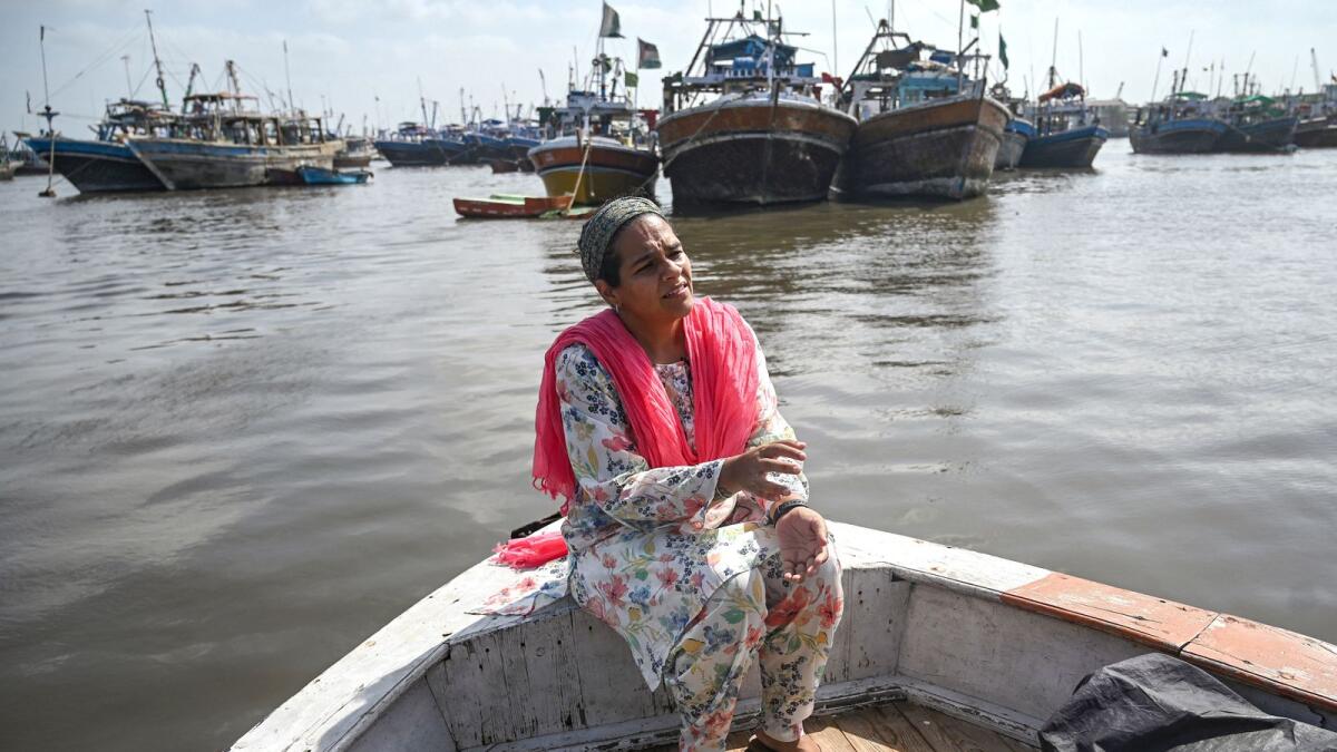 Neha Mankani, a midwife, sits near the shoreline at Baba Island along the Karachi Harbour, in Karachi. AFP