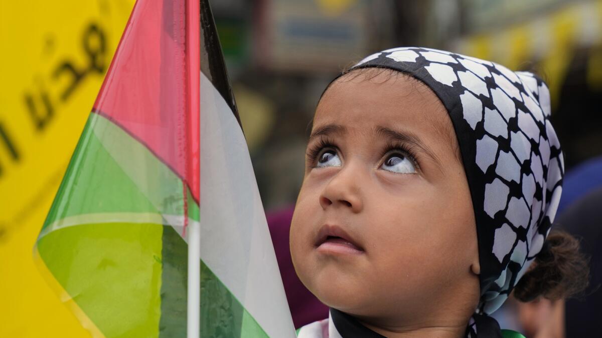 A child holds a Palestinian flag during a protest in solidarity with the Palestinian people in Gaza. — AP
