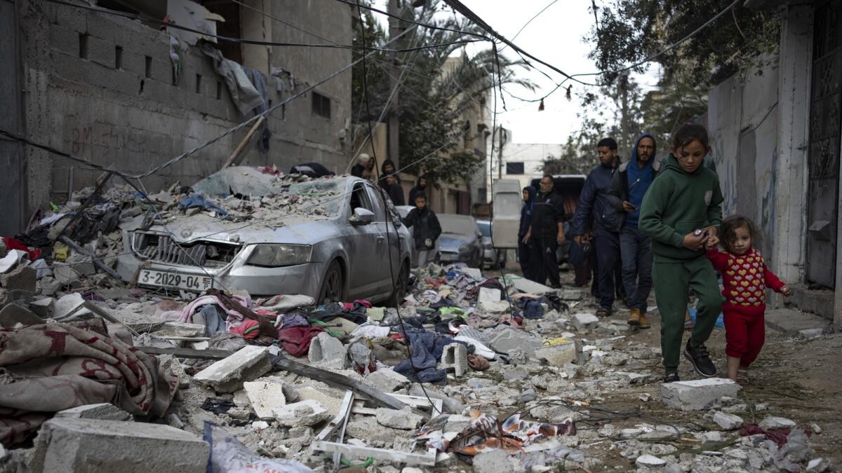 Palestinians look at the destruction after an Israeli airstrike in Rafah. — AP