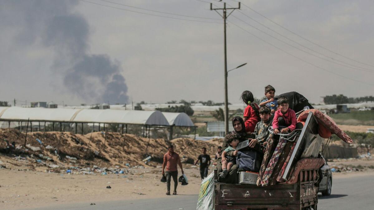 Palestinians fleeing with their belongings ride atop their vehicle in Rafah. — Photo: AFP