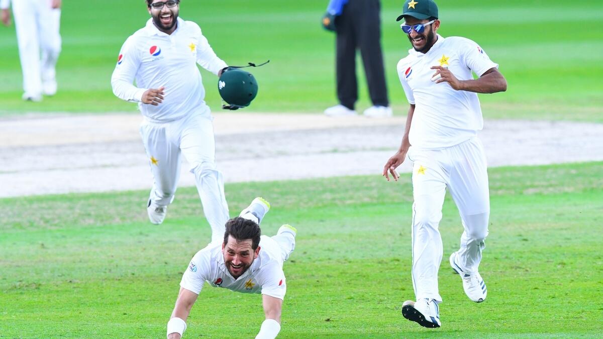 Pakistani bowler Hasan Ali (L) celebrates with teammate Yasir Shah after taking the wicket of New Zealand batsman Tom Latham (R) during the fourth day of the second Test cricket match between Pakistan and New Zealand at the Dubai International Stadium.- A