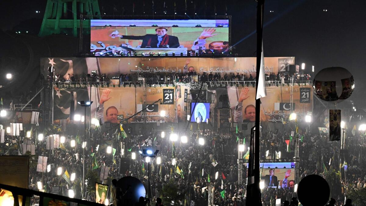 Pakistan's former Prime Minister Nawaz Sharif (top C) addresses his supporters gathered at a park during an event held to welcome him in Lahore. — AFP