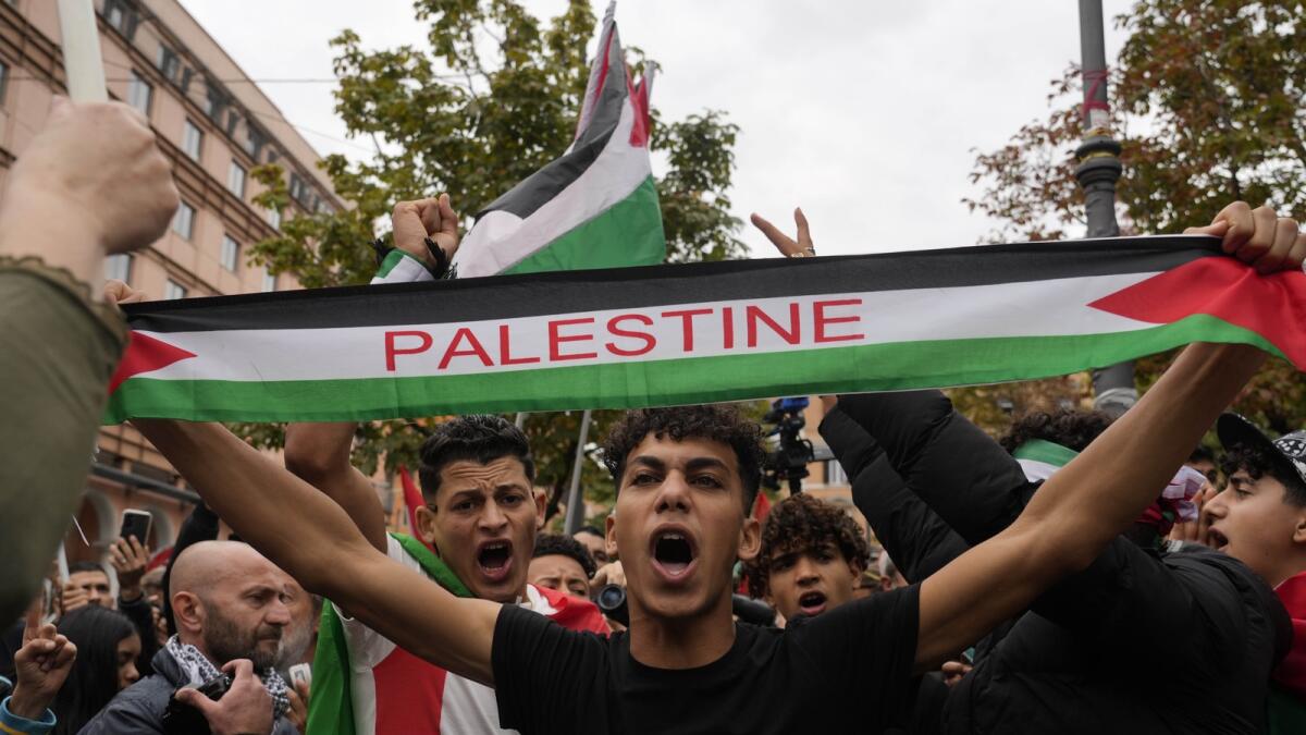 Protesters hold flags and shout slogans gather for a pro-Palestinian rally in Rome. — AP