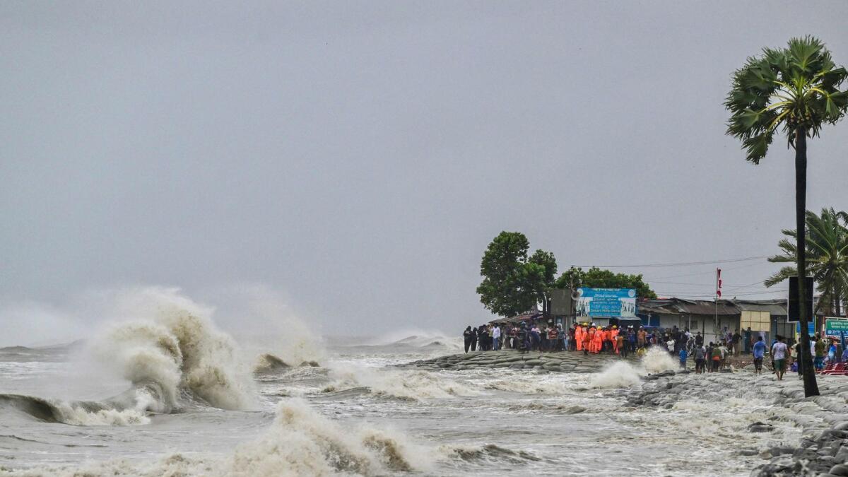 People gather along the sea shore amid rainfall in Kuakata ahead of cyclone Remal's landfall in Bangladesh. — Photo: AFP