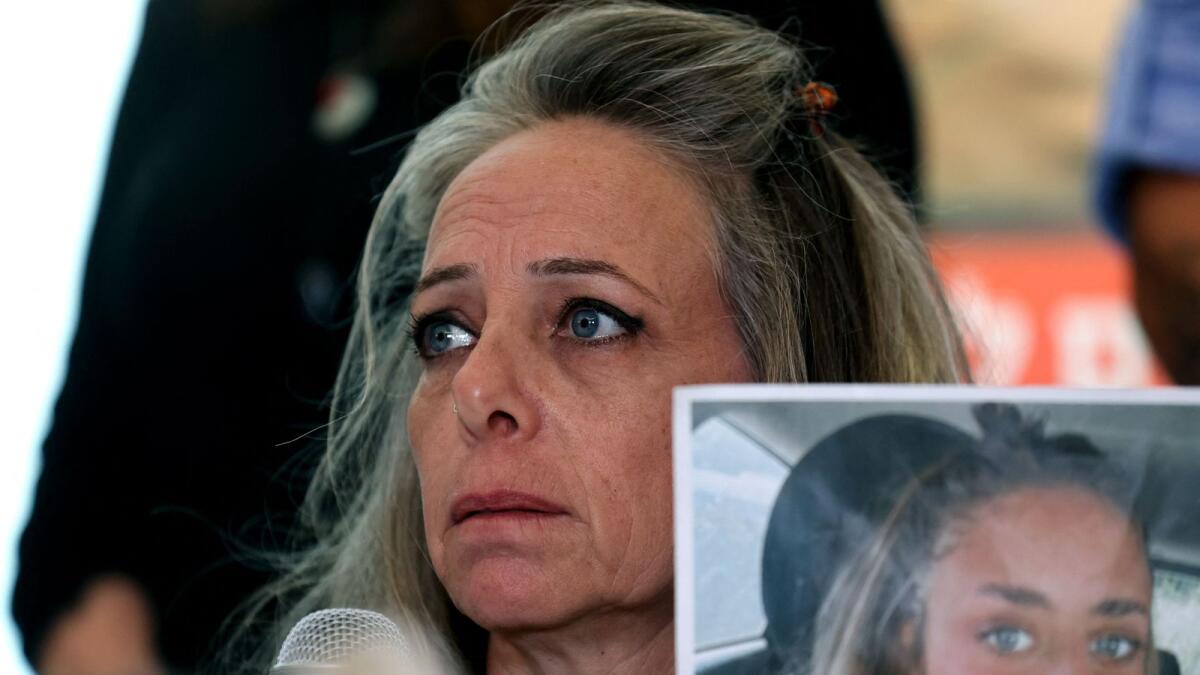 Keren Shem, the mother of French-Israeli woman Mia Shem, held hostage by Hamas militants in Gaza, holds a photograph of her daughter as she speaks to the press in Tel Aviv on October 17, 2023. AFP