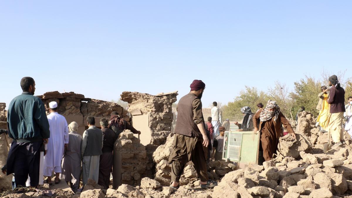 Afghan men clear the debris after an earthquake in Zenda Jan district in Herat province. — AP