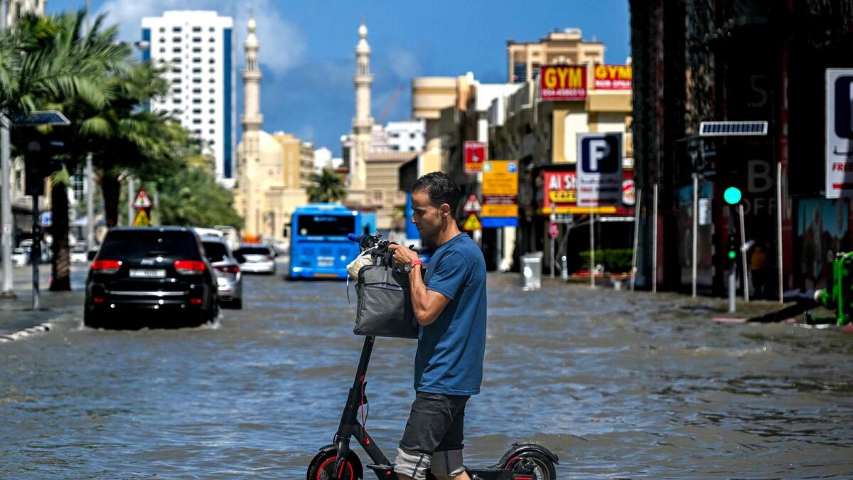 A man crosses a flooded street following heavy rains in Sharjah on April 17, 2024. . Photo: AFP