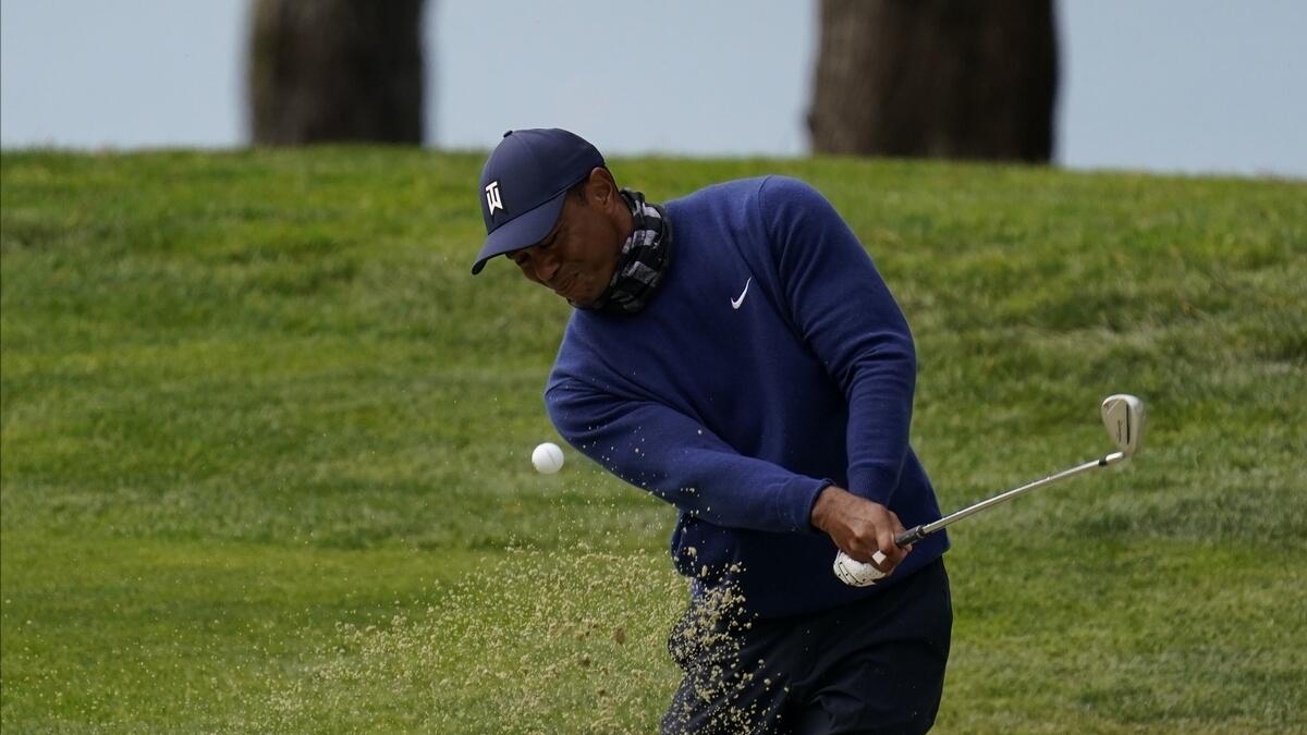 Tiger Woods hits from the bunker on the 14th hole during the first round of the PGA Championship golf tournament