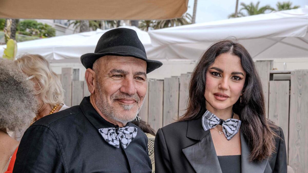 Palestinian film director Rashid Masharawi and Tunisian actress Dorra Zarrouk pose at an event to support Gaza, in Cannes