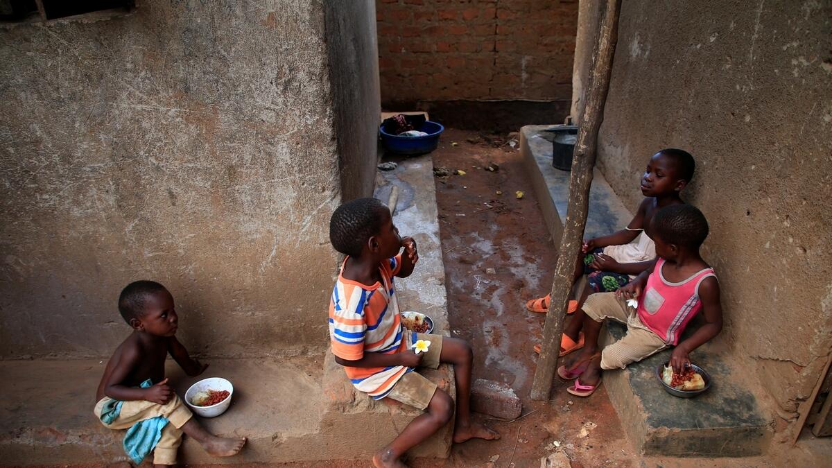 Mariam Nabatanzi's children eat a meal at their family home in Kasawo village.- Reuters