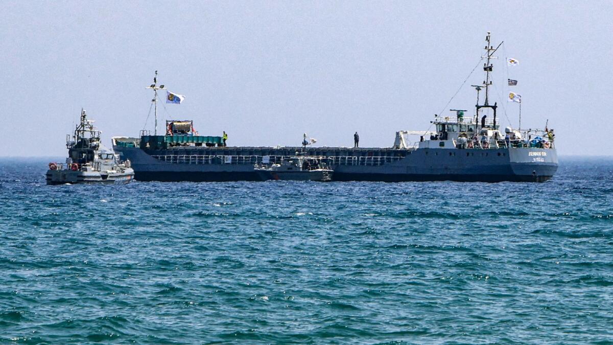 A Cyprus Coast Guard patrol boat approaches the Guinea-Bissau-flagged cargo ship Jennifer, carrying food aid for the Gaza Strip, off the coast of Cyprus' southern port city of Laranca. — AFP