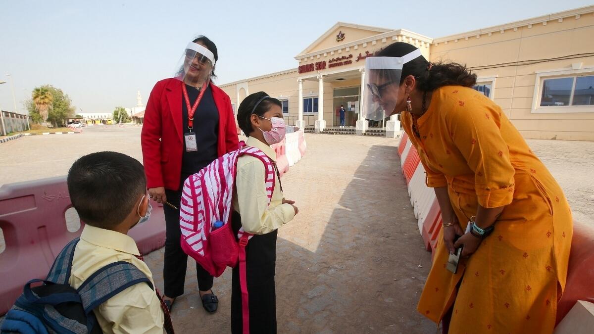 Abhilasha Singh(R) Principal, Shining Star International School, Abu Dhabi greet students as they arrive on the first day of the school term.