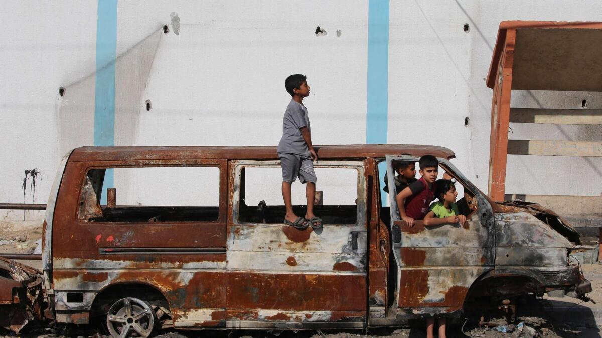 Children play in a charred van in Rafah. — Photo: AFP