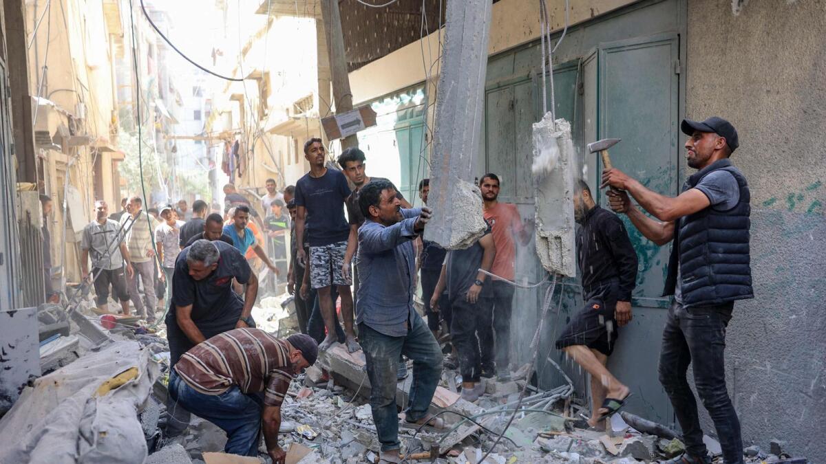 People inspect the damage in the rubble of a building that was damaged during Israeli bombardment at Al Daraj neighbourhood in Gaza City. — Photo: AFP