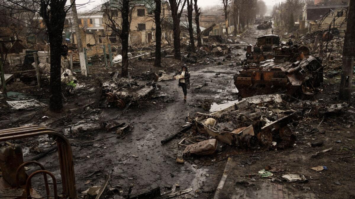 A woman walks amid destroyed Russian tanks in Bucha on the outskirts of Kyiv, Ukraine, on April 3, 2022. The image was part of a series of images by Associated Press photographers that was awarded the 2023 Pulitzer Prize for Breaking News Photography. — AP file