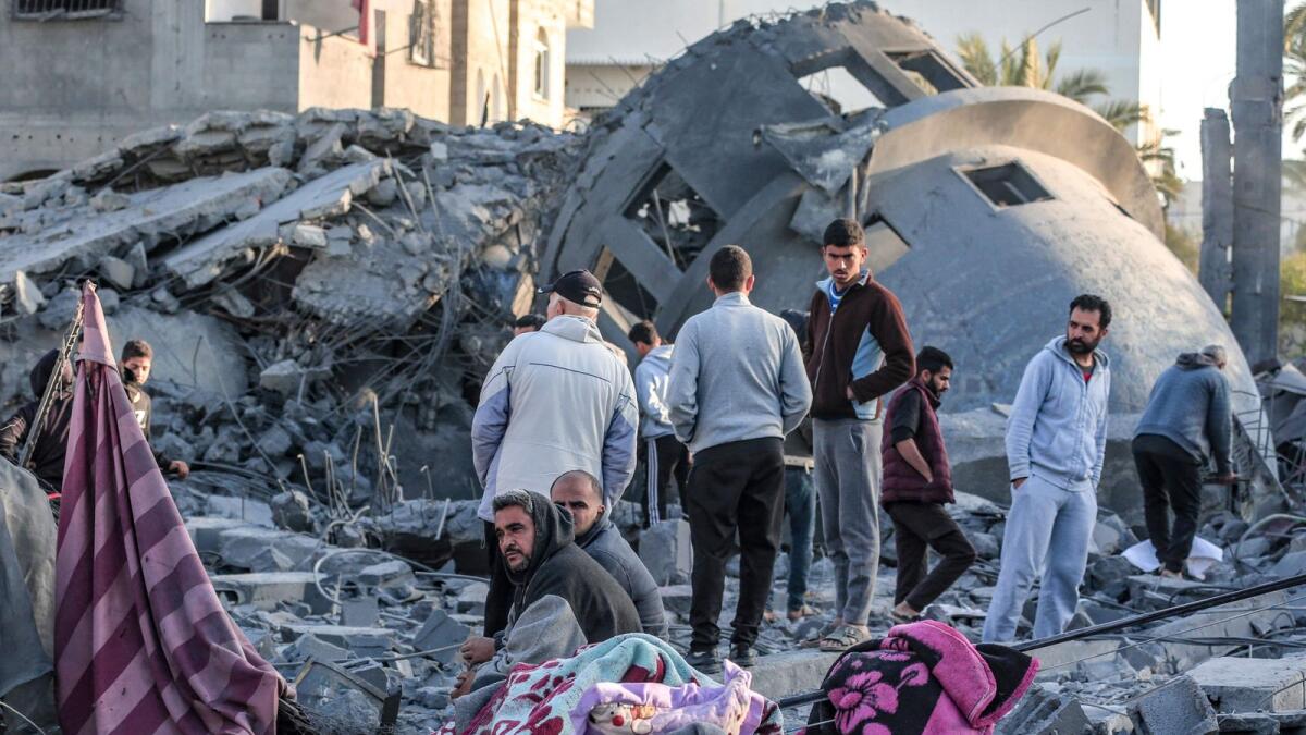 Palestinians stand amid the rubble of a Mosque that was destroyed in Israeli strikes in Deir El-Balah in central Gaza. — AFP