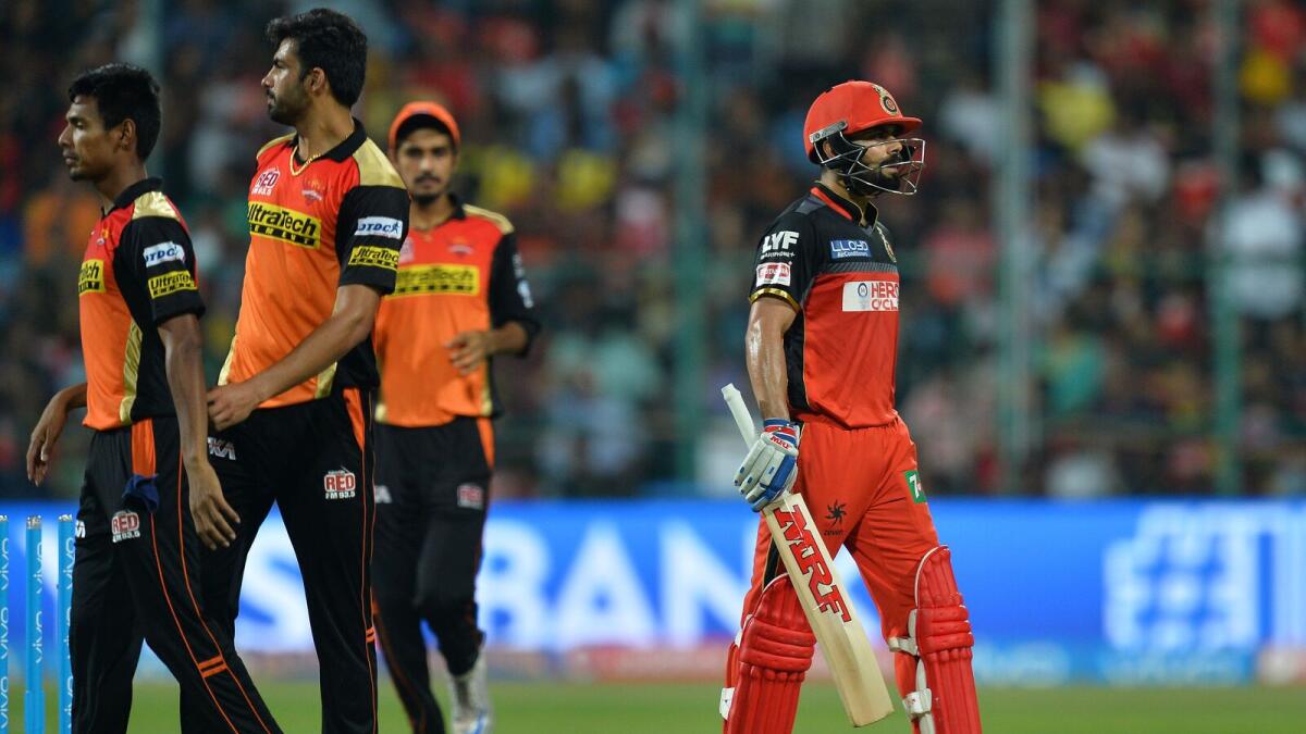 Royal Challengers Bangalore captain and batsman Virat Kohli (R) walks back to the pavilion after being bowled out during the final Twenty20 cricket match of the 2016 Indian Premier League (IPL) between Royal Challengers Bangalore and Sunrisers Hyderabad at The M Chinnaswamy Stadium in Bangalore on May 29, 2016. AFP