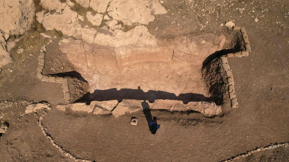 An aerial picture shows a view of a dig revealing an ancient irrigation canal lined with rock carvings dating back to Assyrian times. — AFP