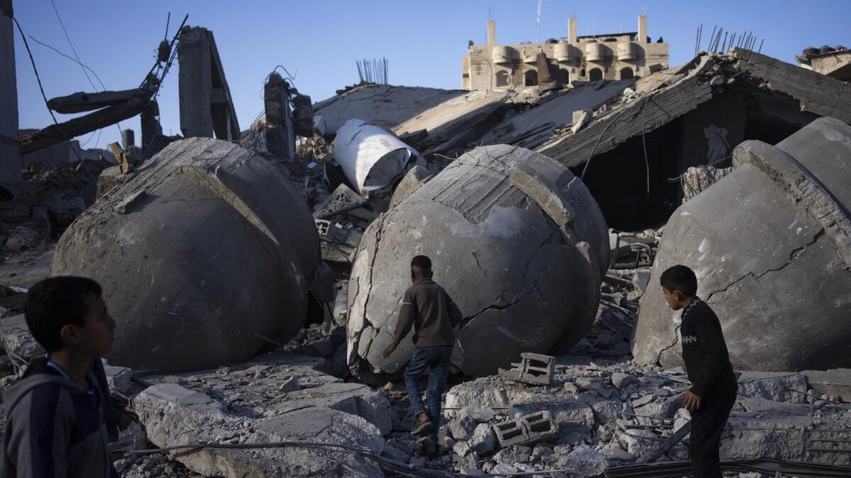 Palestinians look at the destruction after an Israeli strike on residential buildings and a mosque in Rafah. — AP