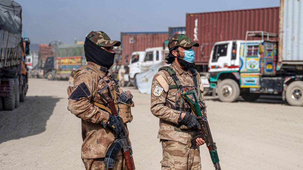 Armed Taliban security personnel stand guard at a cargo truck parking lot at the Afghanistan-Pakistan Torkham border post, in Nangarhar province. -- AFP