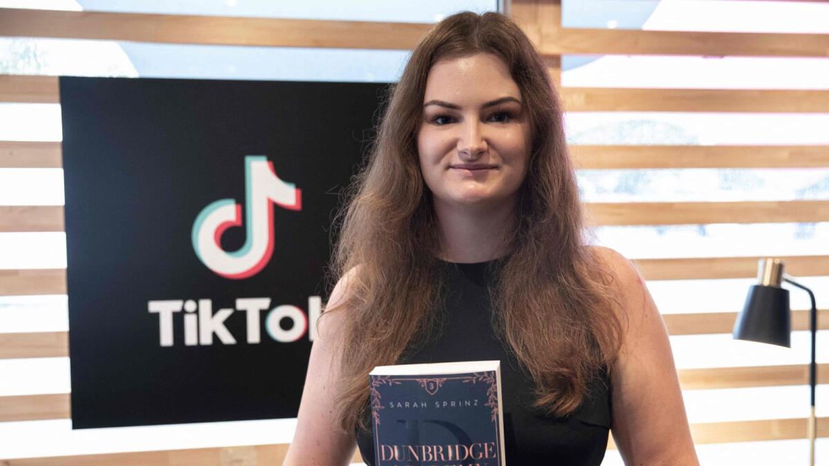 German Author Sarah Sprinz poses for a picture with her book at the TikTok Stands during the 23rd Frankfurt Book Fair on October 21, 2022. — AFP