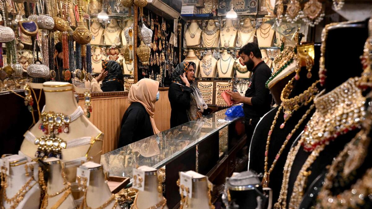 Women shop jewellery at a market in Lahore. — AFP file