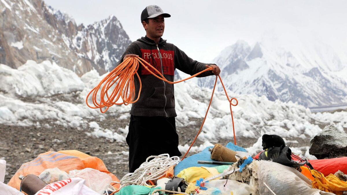 A man collecting litter from K2 at Basecamp, world’s second tallest mountain in the Karakoram range of Gilgit–Baltistan, Pakistan.  Gazing up from K2 Basecamp, Sajid Ali Sadpara sees Earth's second highest mountain, his father's final resting place, and a blight of litter on the furthest reaches of the natural world. -- AFP