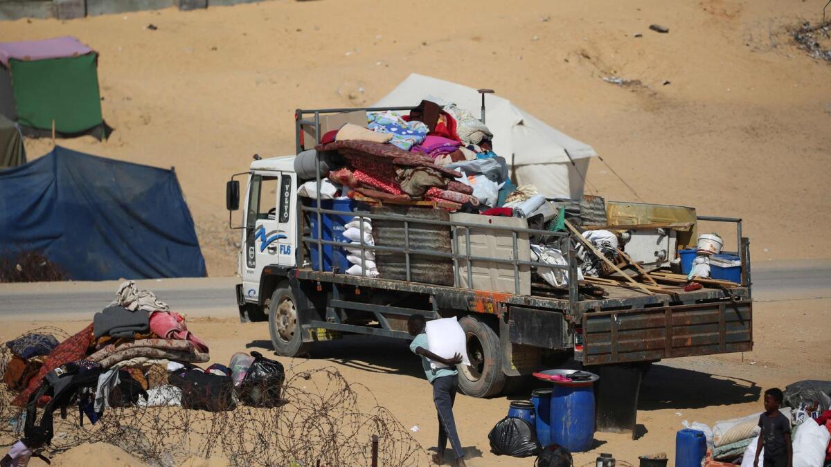 Displaced Palestinians gather their belongings on the back of a truck as they flee to a safer area in Rafah. — Photo: AFP